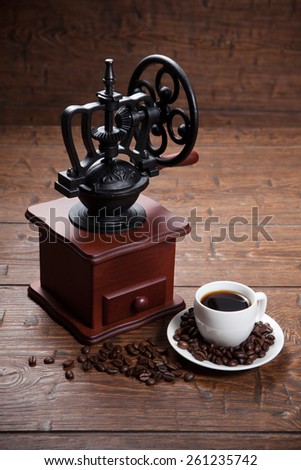 Cup of coffee with coffee beans and coffee mill. Still life with coffee.