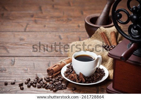 Cup of coffee with coffee beans and coffee mill. Still life with coffee.
