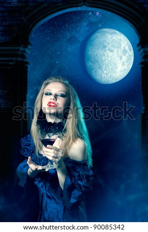 Vampire girl in a dress with glass of wine
