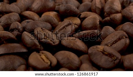 Raw Coffee beans background with focus on one grain