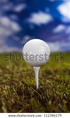 Golf ball on green grass over a blue sky