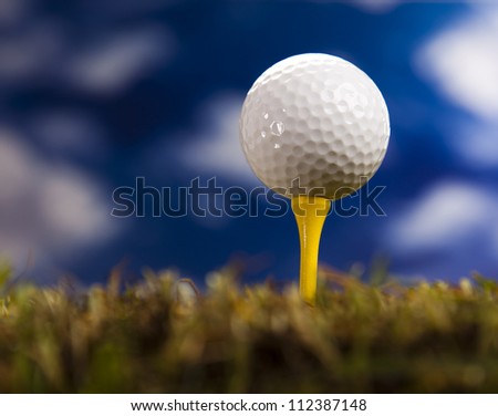 Golf ball on green grass over a blue sky