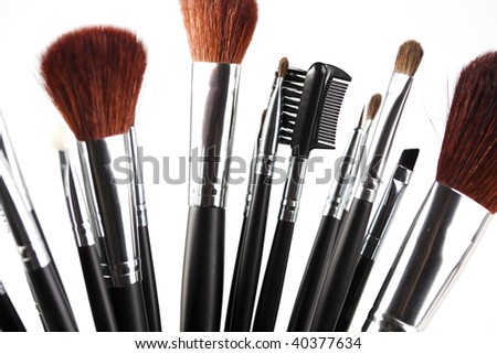 Cosmetic powder and black brushes isolated