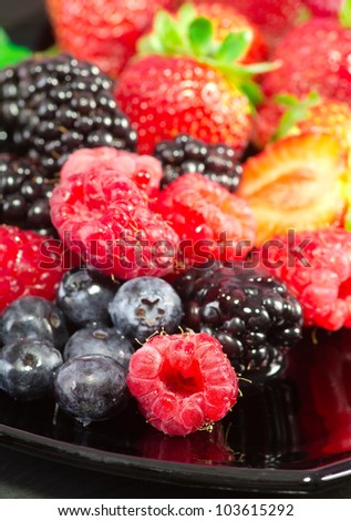 healthy red fruits over black plate