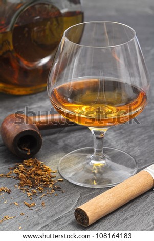 brandy glass with smoke pipe and cigar