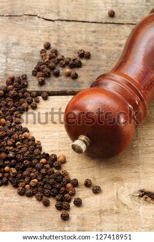 black pepper grains and pepper grinder