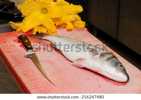sea bass with fish knife and pumpkin flowers