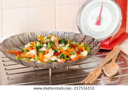 vegetable steamer with vegetables MIX INSIDE AND BALANCE OVER DRAINING BOARD