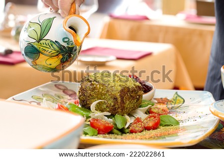serving dish with tuna fillet cooked in sesame and pistachio crust with fresh vegetable garnish