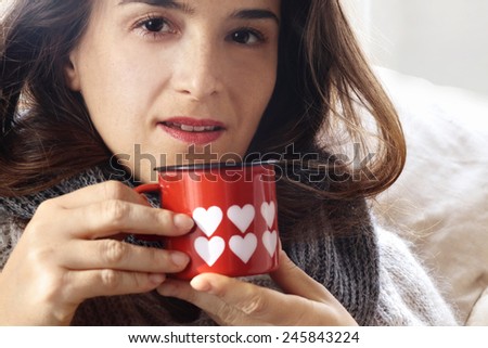 alluring girl drinking something from Valentine decorated mug