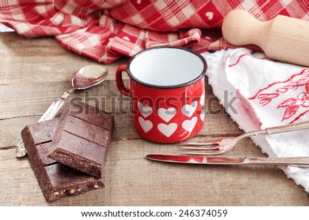 Valentine hearts decorated mug with Modica chocolate and vintage silverware over wood