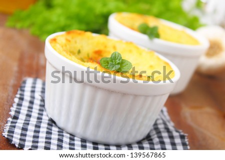 shepherd\'s pie. lamb meat, mashed potatoes and grated cheese served in a small bowl.