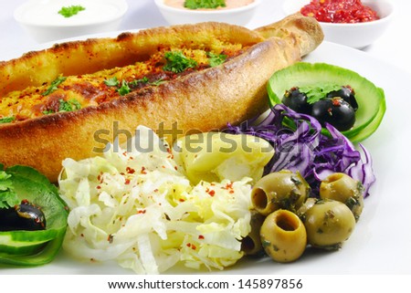turkish pide with cheese, iceberg salad, olives, red cabbage and cucumber