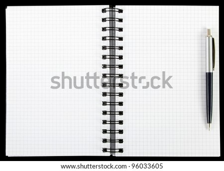 Empty notebook with squared pages and a pen over a black background
