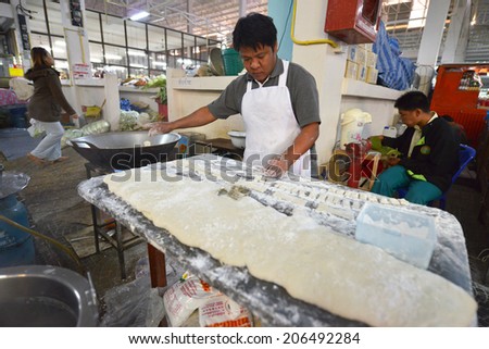 MAE HONG SON, THAILAND - FEBRUARY 18: An unidentified man making fritters in the market on February 18, 2014 in Mae Hong Son, Thailand.