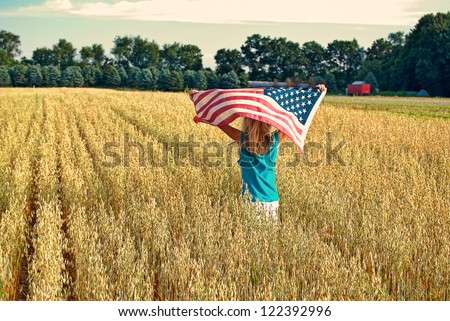 girl running with wheat field with American flag