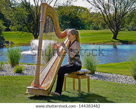 Young Woman Playing A Harp On A Golf Course
