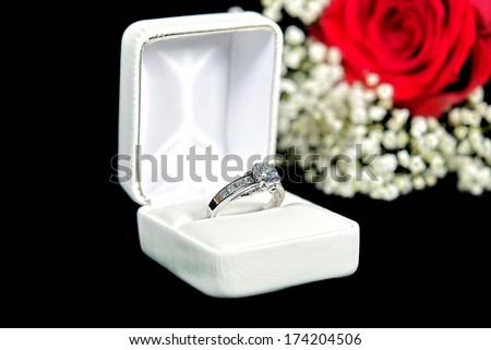 diamond ring in ring box with red rose