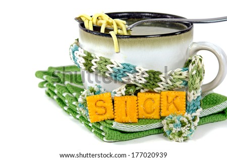 chicken noodle soup in cup with winter scarf and crackers