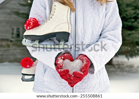 young girl wearing red gloves with ice heart and ice skates