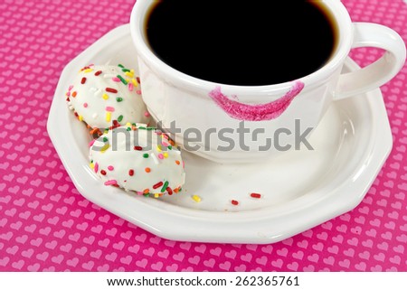 pink lipstick on coffee cup with cookies and sprinkles