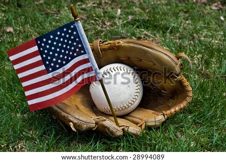 Baseball, glove and flag on green grass