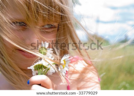young girl with daisies in the wind