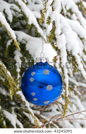 blue ornament and snow on tree