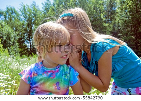 little girl whispering a secret