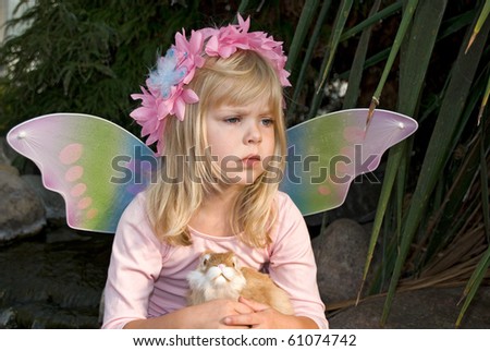 little girl with fairy wings holding a bunny