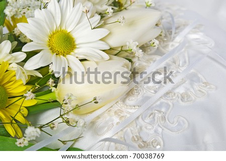 stock photo tulip and daisy wedding bouquet on satin pillow