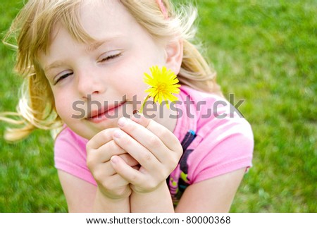 Little girl with lady bug and dandelion