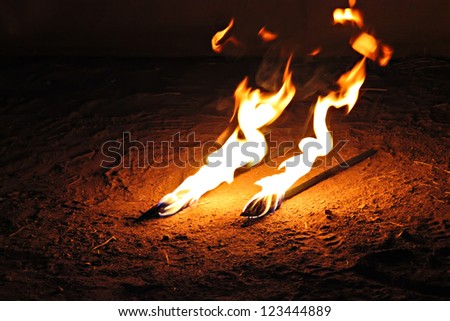 Fire sticks for the jugglery burning on the ground