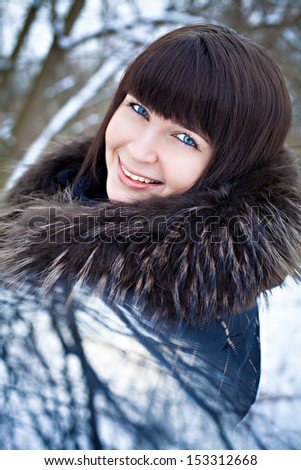 Outdoor portrait of a young woman in winter dress with fur