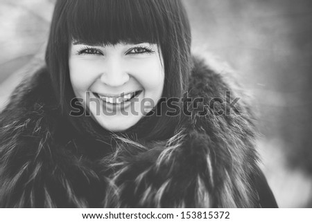 Outdoor portrait of a young woman in winter dress with fur