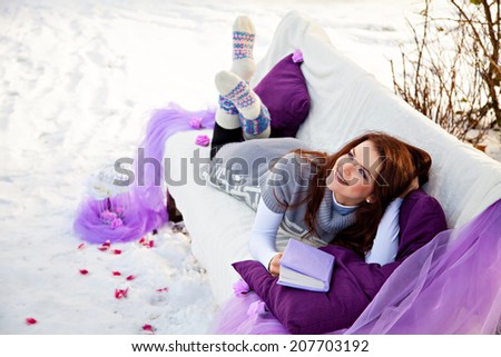 Woman dreaming at winter forest lying on the couch