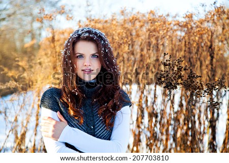 Woman with snow on hair in winter park