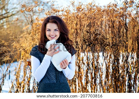 Woman with heater in hand in winter outdoors