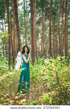 Pretty girl with angel wings in the forest