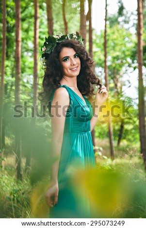 Pretty girl in green dress in the forest
