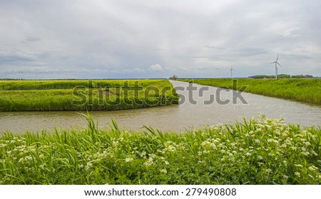 Canal through a rural landscape under deteriorating weather