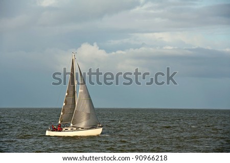 Sailing boat sailing on a lake in fall, Netherlands