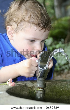 Toddler playing with a drinking fountain
