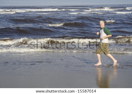 A young man runs along the ocean shore in the morning