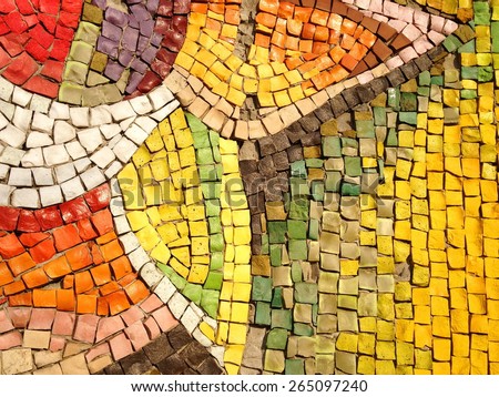 Colorful old stone mosaic on the wall, bright tiles, floral theme
