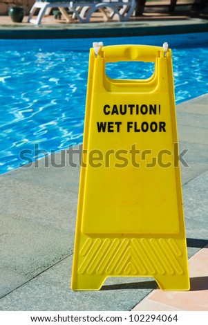 Sign with caution wet floor near the swimming pool