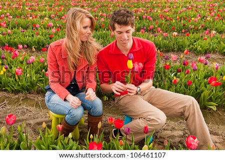 Young couple in Dutch flower fields with colorful tulips