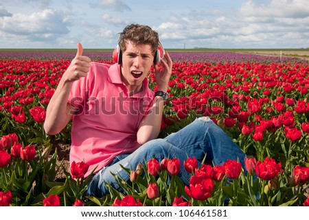 Dutch man sitting in flower fields listening to cool music