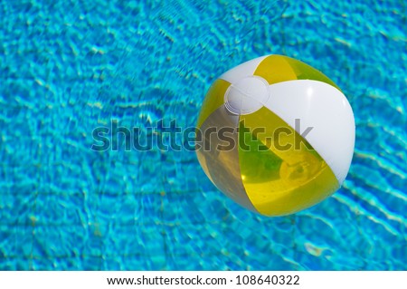 Inflatable yellow beachball floating at the water