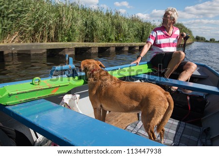 Man with dog in boat on the river